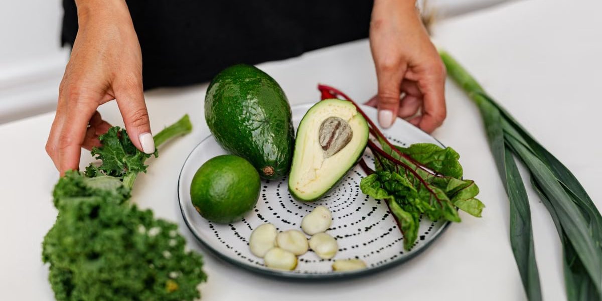 Top view of assorted fresh ingredients including avocado and kale on a plate. Perfect for healthy eating themes.