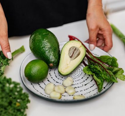 Top view of assorted fresh ingredients including avocado and kale on a plate. Perfect for healthy eating themes.